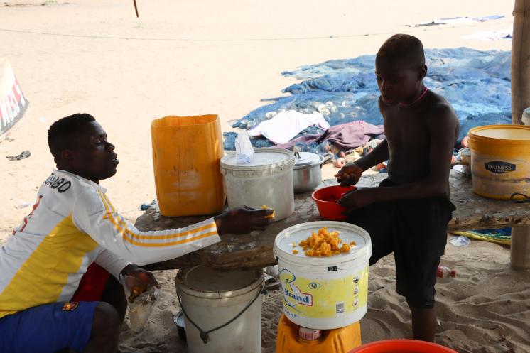 A fisherman and his son having an afternoon meal in Atuabo.  